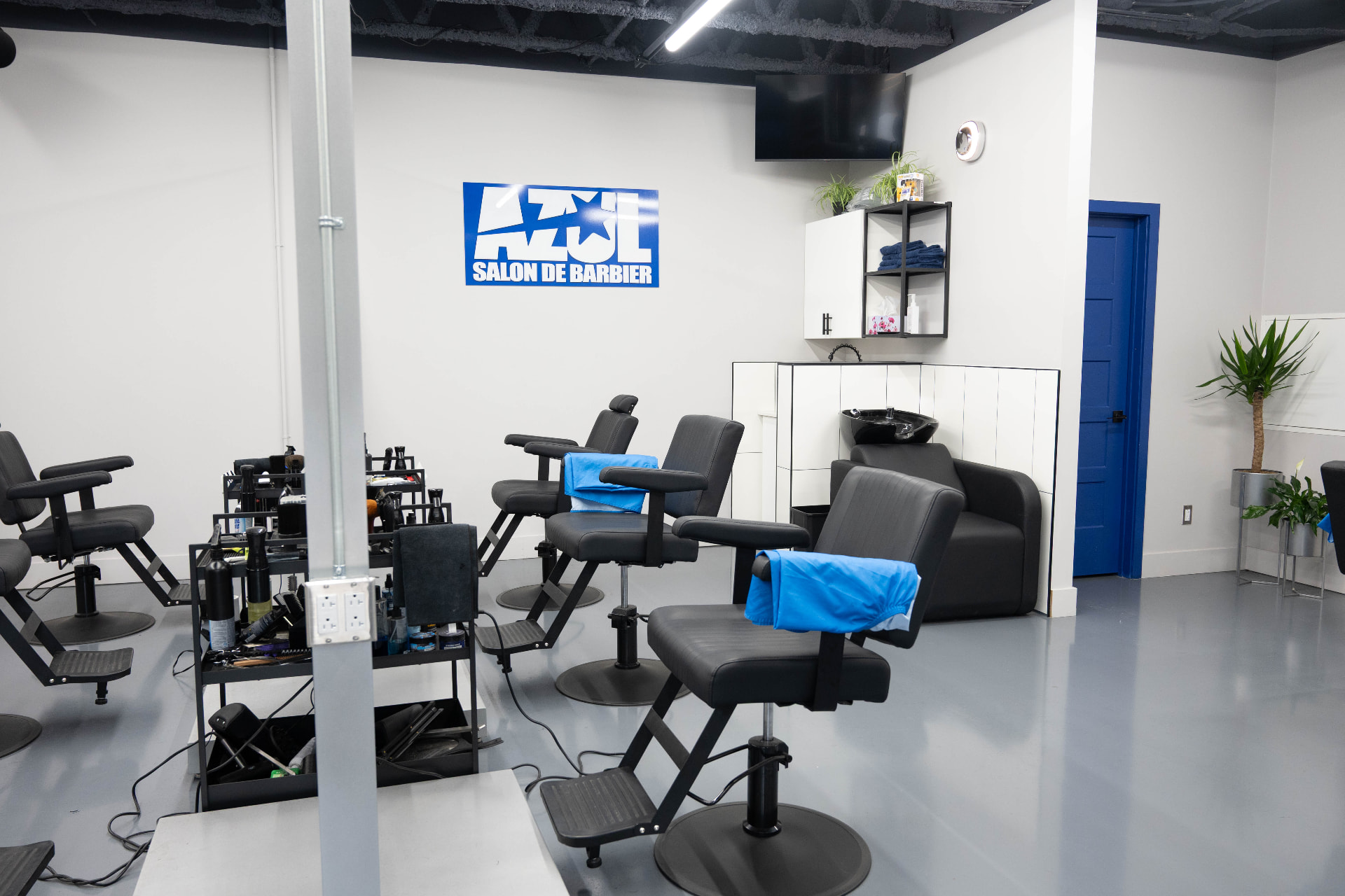 L'intérieur du Salon Barbier Azul à Laval, avec ses fauteuils de barbier et son enseigne